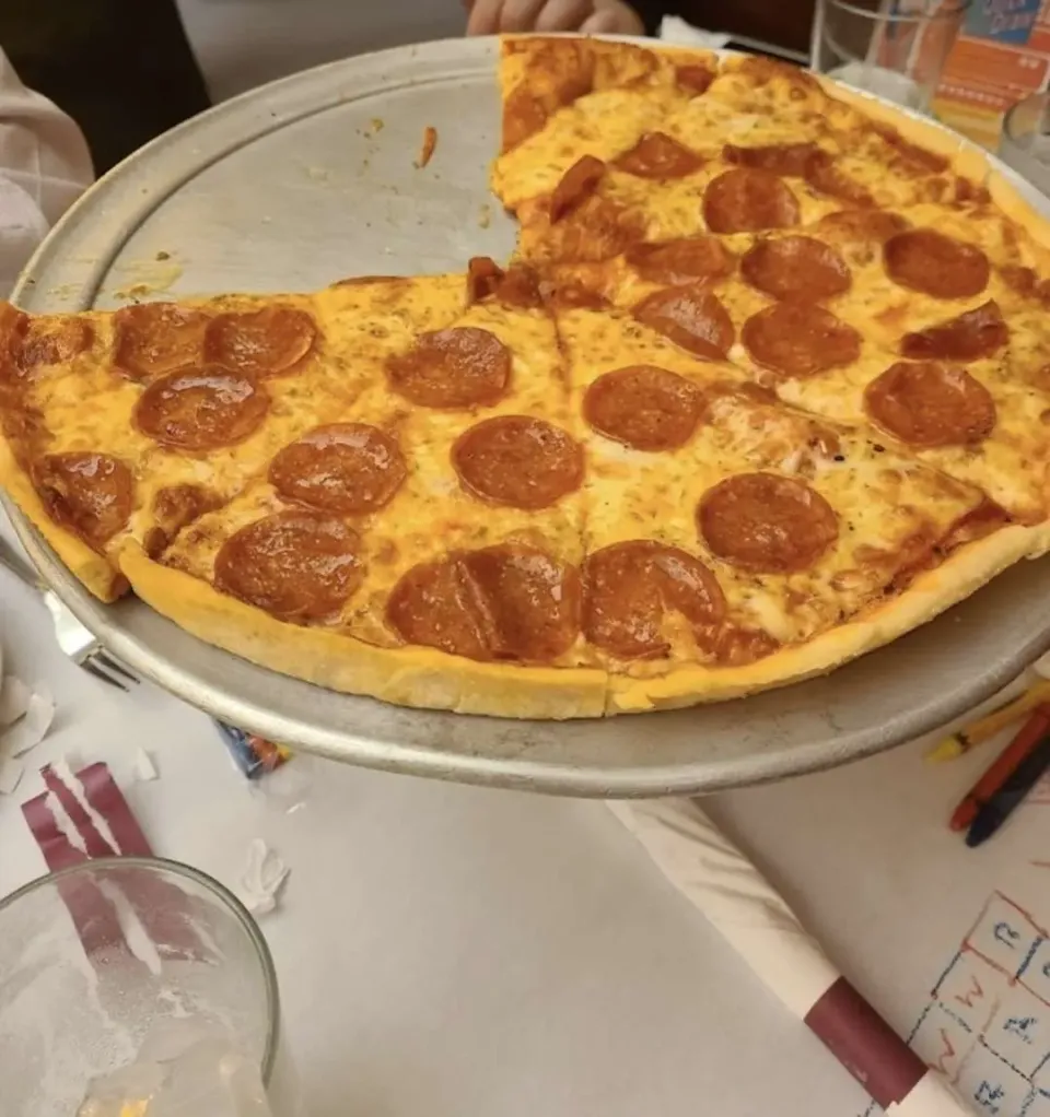 Pizza de pepperoni cortada en porciones