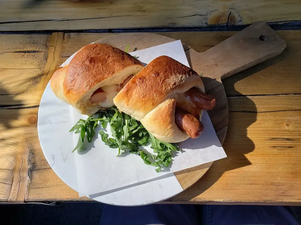 Hot dogs en pan horneado con hojas verdes