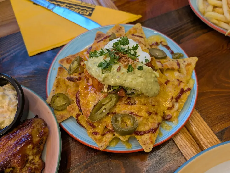 Nachos cargados con guacamole, jalapeños y crema